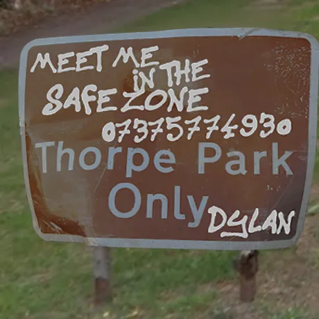 Road sign reading : Meet Me in the safezone 07375774930. Thorpe Park Only. Written by someone called Dylan